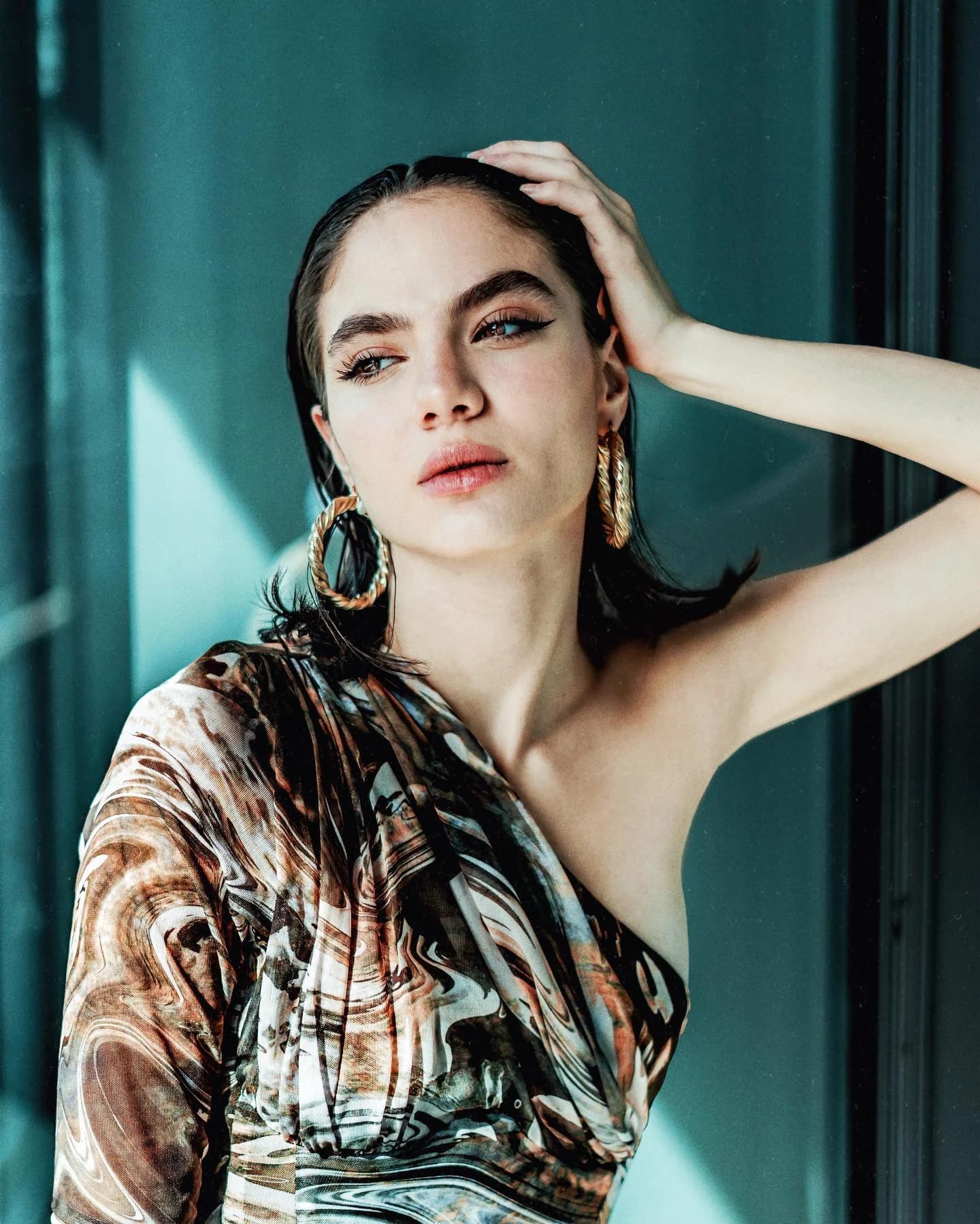 Daylight portrait with sculptural gold earrings