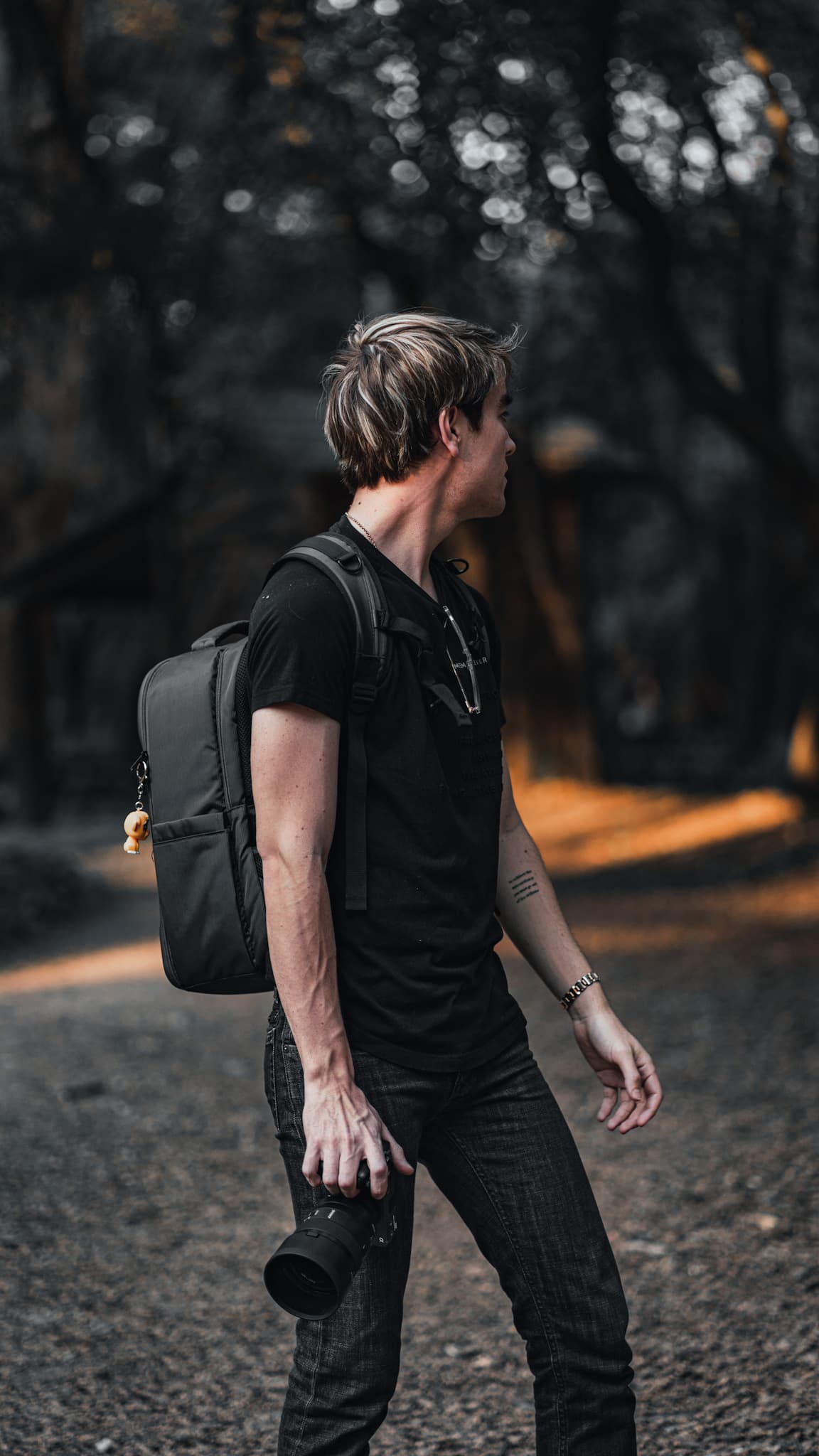Photographer walking through a forest with a camera